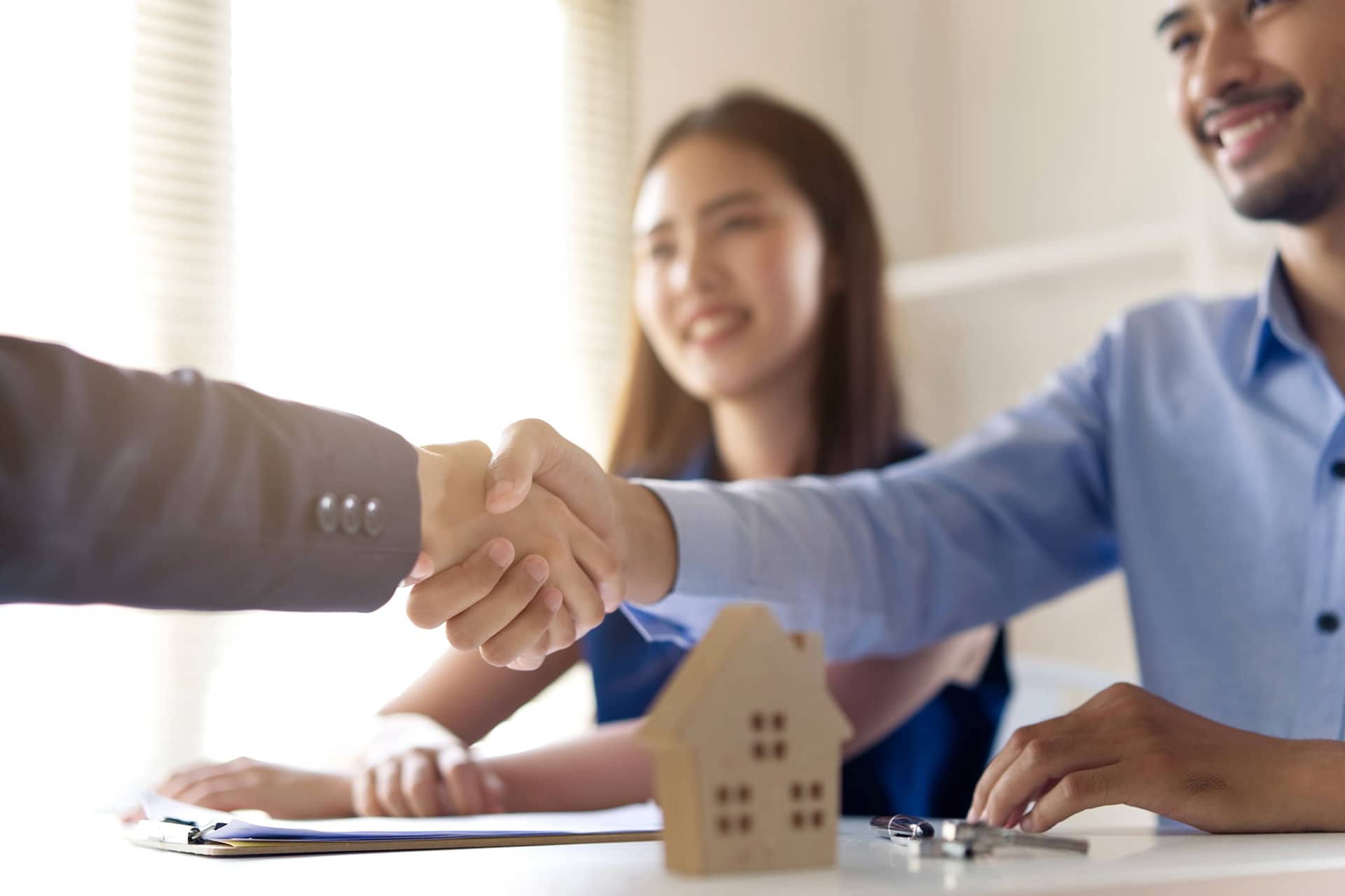 Handshake between letting agent and happy couple for a new home move-in with Chelton Brown, Northamptonshire.