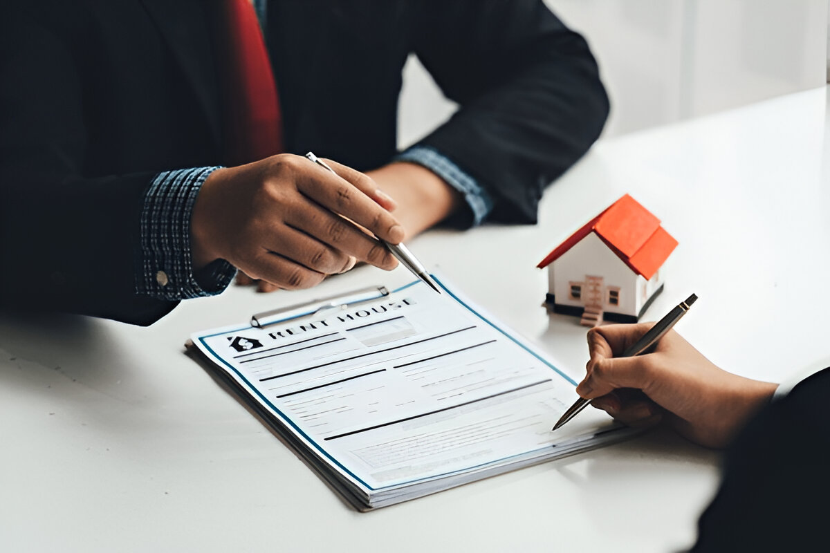 Agent pointing to house rental application form being signed at Chelton Brown, letting agents in Northamptonshire.
