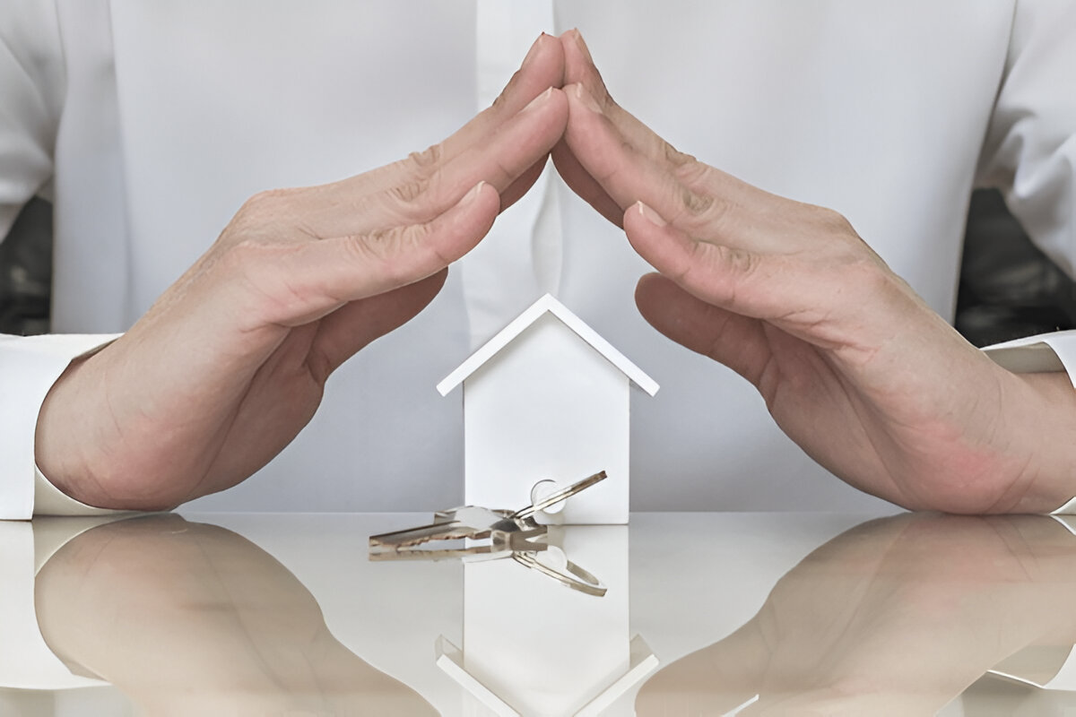 Hands shielding a house model to represent tenant responsibilities and property care at Chelton Brown, Northamptonshire.