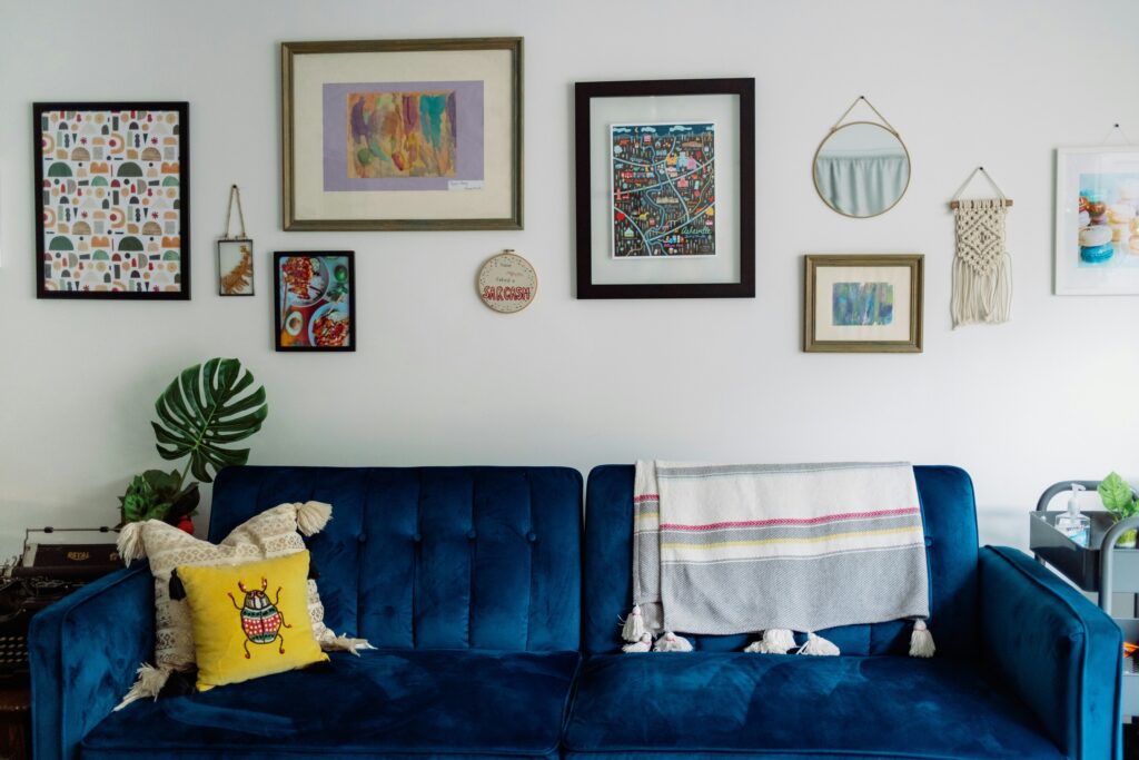 Blue velvet sofa and eclectic gallery wall in a Northamptonshire rental home, from Chelton Brown’s tenant moving guide.