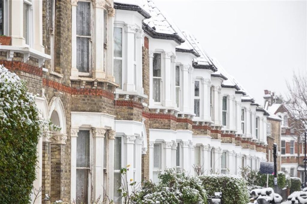 Snow-covered terraced houses in Northampton, featuring winter home maintenance advice from Chelton Brown estate agents.