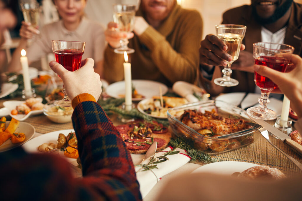 Friends toasting at a Christmas dinner party in a Northamptonshire home, following Chelton Brown's hosting guide.