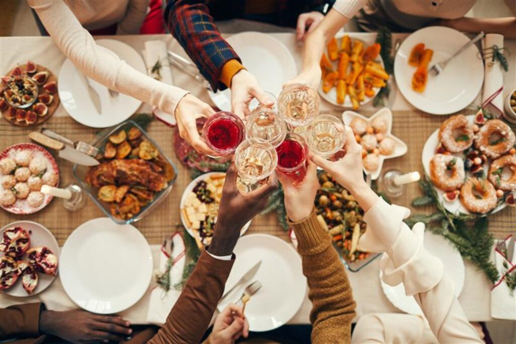 Friends toasting at a festive dinner party in a Northamptonshire home, following Chelton Brown winter hosting tips.